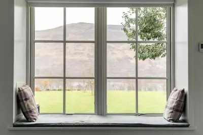 a window with a view of a green field at Dalveich Cottage, hot tub, 2 bedroom, Lochearnhead in Lochearnhead