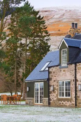 a stone house with a table and a bench at Dalveich Cottage, hot tub, 2 bedroom, Lochearnhead in Lochearnhead