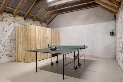a ping pong table in a room with a wooden wall at Dalveich Cottage, hot tub, 2 bedroom, Lochearnhead in Lochearnhead