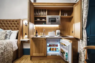 a small kitchen with a sink and a refrigerator at Bonnie Hotel - Smart Boutique ApartHotel - Haymarket Edinburgh in Edinburgh