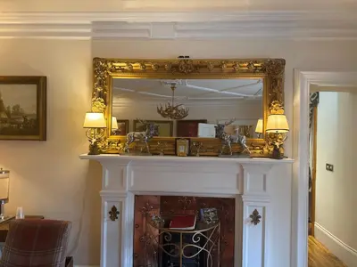 a fireplace with a mirror on top of it at The West Highland Way Hotel and Retreat Accommodation in Glasgow