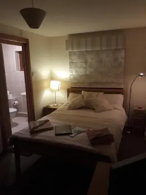 a bedroom with a bed with a lamp and a book on it at Garragh Mhor in Oban