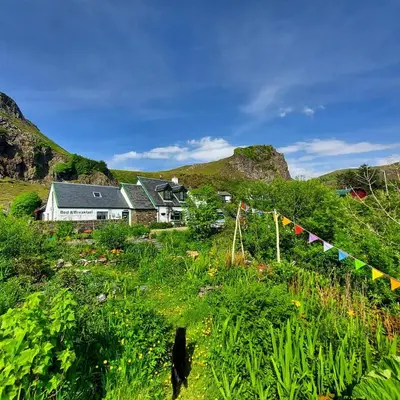 a house on a hill with flags in a field at Garragh Mhor in Oban