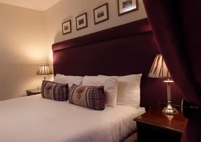 a hotel room with a bed with two pillows at Loch Leven Hotel & Distillery in Glencoe