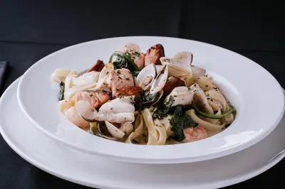 a bowl of pasta with shrimp and broccoli on a plate at The Royal Hotel Campbeltown in Campbeltown