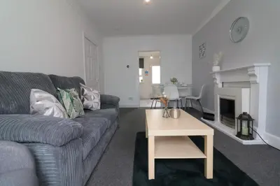 a living room with a couch and a table at Signature - Gartlea House in Airdrie