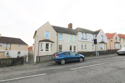 a blue car parked in front of a row of houses at Signature - Gartlea House in Airdrie