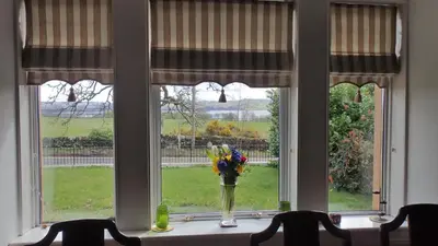 a vase of flowers sitting on a window sill at Arrochoile in Balmaha