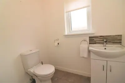 a bathroom with a toilet and a sink and a window at Signature - Morrison House in Glasgow