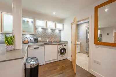 a kitchen with a washing machine and a washer at Mandarin Premier Apartments D 2 Bed Apt 1st Floor in Oban