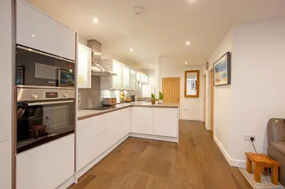 a kitchen with white cabinets and a counter top at Mandarin Premier Apartments D 2 Bed Apt 1st Floor in Oban