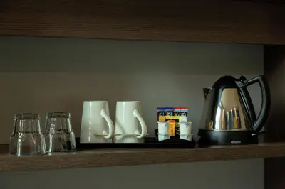 a shelf with a coffee pot and glasses on it at Hampton By Hilton Hamilton Park in Hamilton