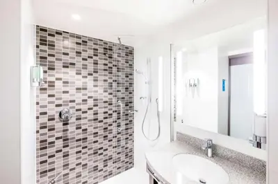 a bathroom with a shower and a sink at Hampton By Hilton Hamilton Park in Hamilton