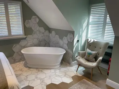 a bathroom with a large tub and a chair at Bagpipers Luxury Hideaway Glencoe Ballachulish Highlands Near Fort William in Glencoe