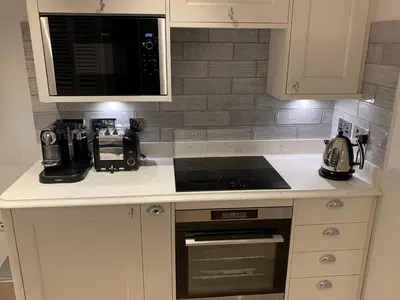 a kitchen counter with a microwave and a stove top oven at Bagpipers Luxury Hideaway Glencoe Ballachulish Highlands Near Fort William in Glencoe