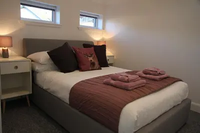 a bedroom with a bed with two towels on it at The Wee Bank House in Oban