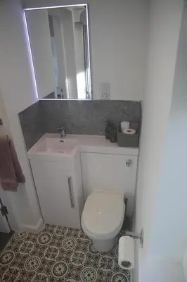 a bathroom with a white toilet and a sink at The Wee Bank House in Oban