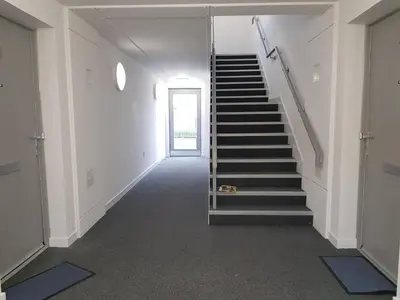 a hallway with stairs in a building with a door at 1 Royal View Apartments in Stirling