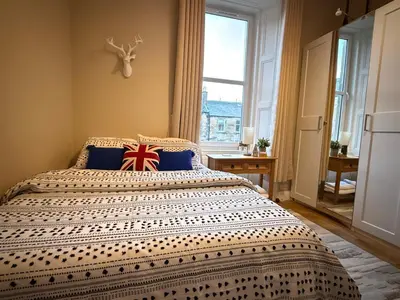 a bedroom with a bed with a british flag pillow on it at Murrayfield Spacious 2-bedroom apartment in Edinburgh