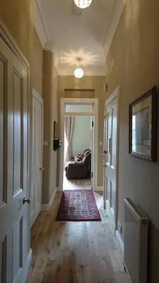 a hallway of a home with a couch in the distance at Murrayfield Spacious 2-bedroom apartment in Edinburgh
