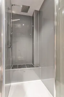 a shower with a glass door in a bathroom at Murrayfield Spacious 2-bedroom apartment in Edinburgh