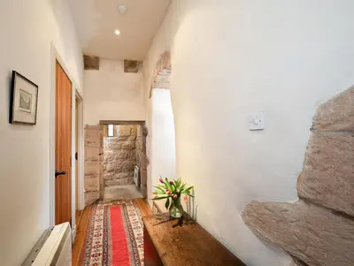 a hallway with a wooden table with a vase on it at Braidwood Castle - Uk10672 in Braidwood