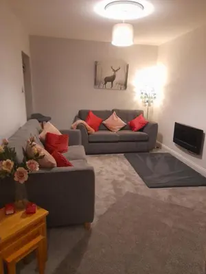 a living room with a couch and a tv at The old post office Callander holiday let in Callander