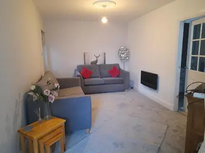 a living room with a couch and a tv at The old post office Callander holiday let in Callander