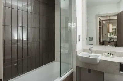 a bathroom with a sink and a glass shower at Dalmeny Park House Hotel in Barrhead