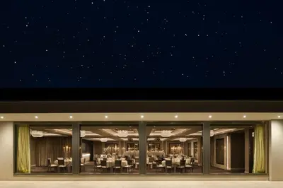 a restaurant with tables and chairs at night at Dalmeny Park House Hotel in Barrhead