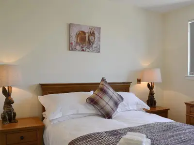a bedroom with a bed with white sheets and pillows at Blueacres in Skirling