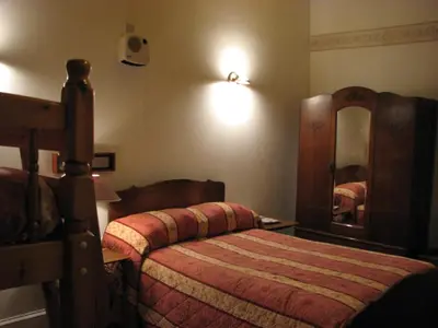 a bedroom with a bed and a mirror at Lancaster Hotel in Oban