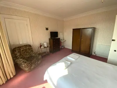 a hotel room with a bed and a chair at Dunrigh Guest House in Oban