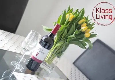 a bottle of wine and a vase with flowers at Albion Apartment by Klass Living Coatbridge in Coatbridge