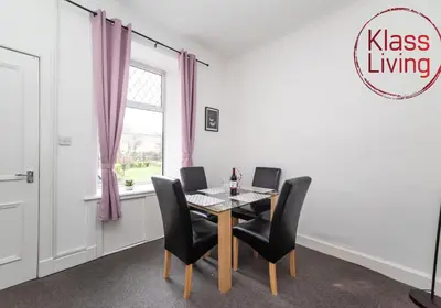 a dining room with a table and chairs and a window at Albion Apartment by Klass Living Coatbridge in Coatbridge