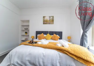 a bedroom with a large white bed with yellow pillows at Albion Apartment by Klass Living Coatbridge in Coatbridge