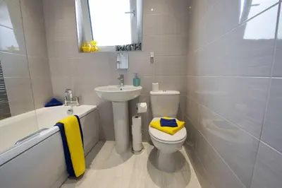 a bathroom with a white toilet and a sink at PREMIER - Garfield House in Bellshill