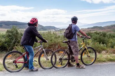 two people standing next to their bikes on a road at Portavadie Loch Fyne Scotland in Portavadie