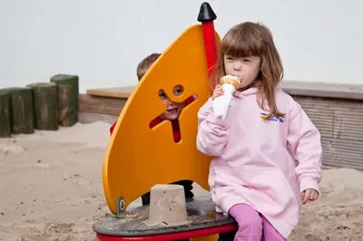 a little girl eating ice cream at a playground at Portavadie Loch Fyne Scotland in Portavadie
