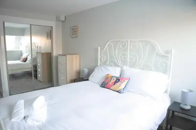 a bedroom with a large white bed with a pillow at The Stables - Fabulous stylish flat in Merchant City & Free Secure Parking in Glasgow