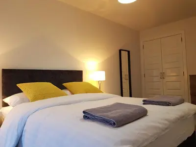a bedroom with a large white bed with yellow pillows at 7 Royal View Apartments in Stirling