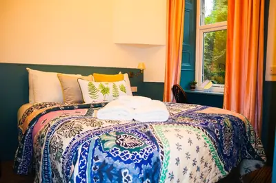 a bedroom with a bed with pillows and a window at New Town Guest House (Adults Only) in Edinburgh