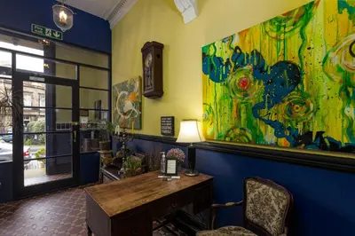 a room with a table and a large painting on the wall at New Town Guest House (Adults Only) in Edinburgh