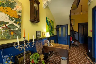 a hallway with a table and a clock on the wall at New Town Guest House (Adults Only) in Edinburgh