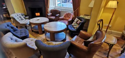 a living room filled with furniture and a table at Buccleuch and Queensberry Arms Hotel in Thornhill