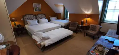 a hotel room with two beds and a table at Buccleuch and Queensberry Arms Hotel in Thornhill