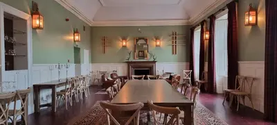 a dining room with tables and chairs and a fireplace at Buccleuch and Queensberry Arms Hotel in Thornhill