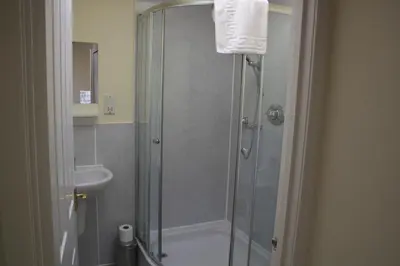 a bathroom with a shower and a toilet and a sink at Fairways Cottages in Prestwick