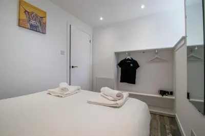 a white room with a bed with towels on it at Abbey House in Paisley
