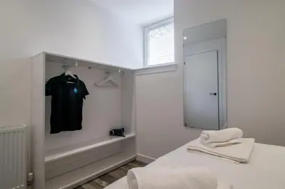 a white room with a black shirt in a closet at Abbey House in Paisley